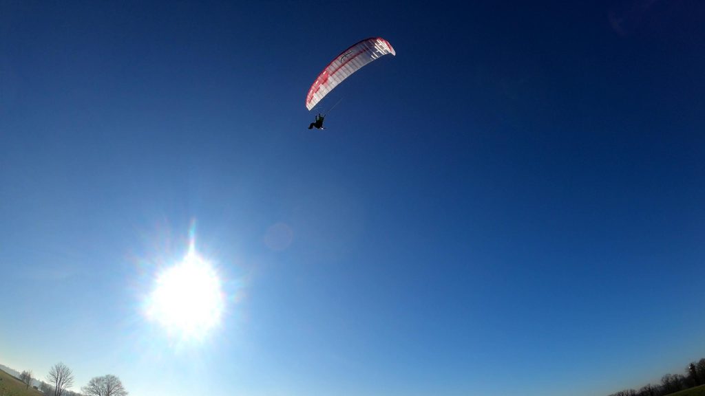 RC-Gleitschirm fliegt am Himmel. Hybrid Stable 2.1 Race RAST im Hintergrund die Sonne.