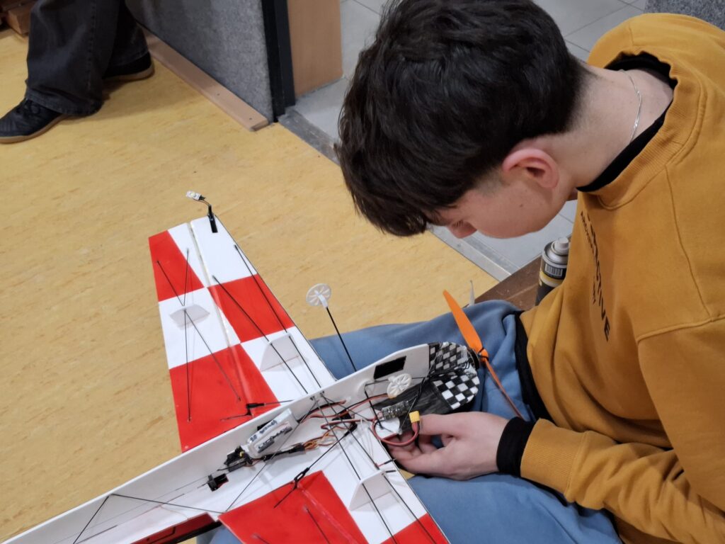 Hallenfliegen in der Sporthalle Claussnitz. Ein Flugmodell wird vorberereitet.
