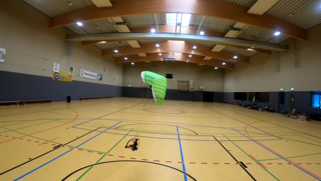 Hacker Cloud 0.5 mit einem Trike fliegt in einer Sporthalle.