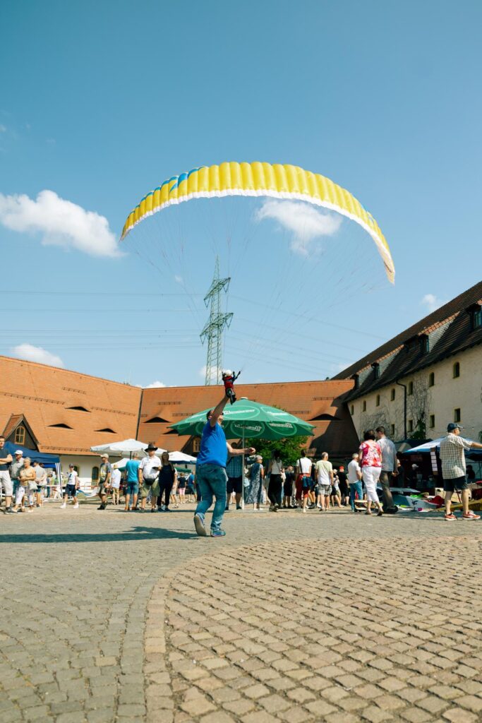 1.Modellsommer Wasserschloss Klaffenbach. Roland Richter zieht einen RC-Gleitschirm Phasor 2.3 RAST mit einem Piloten "Noah" im Sitzgurtzeug auf.