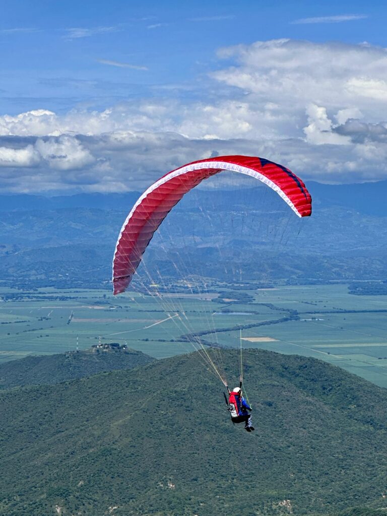 Das Para Aviation RC-Sitzgurtzeug „Noah V2“ fliegt zusammen mit einem RC-Paraglider „Phasor 2.3 RAST“ vor einer Bergkulisse.
