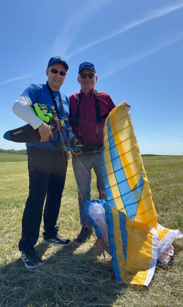 Eine Para Aviation RC-Kundenschulung auf einer grünen Wiese mit einem RC-Gleitschirm „Phasor 2.3 RAST“ und dem Liegegurtzeug „Rocket V2“.