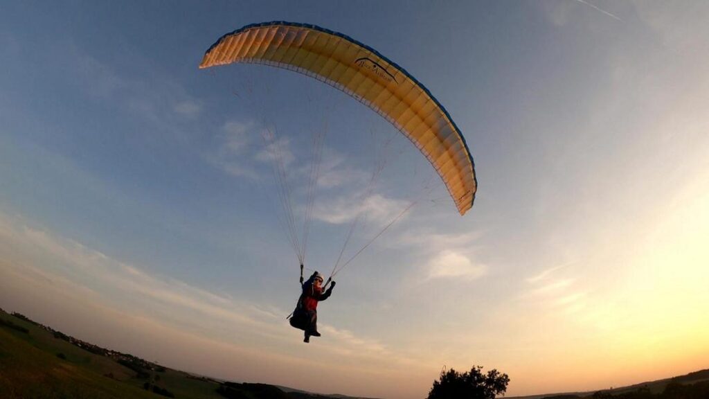 Ein RC-Doppelskin-Gleitschirm „Phasor 2.3 RAST“ fliegt mit der Pilotenfigur „Noah“ im Sitzgurtzeug „Noah V2“ während eines Abendflugs über das Muldental.
